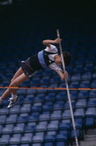 Competitor in junior athletics championship at Crystal Palace clearing bar in pole vault.