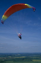 Paraglider with multicoloured chute.