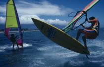 Jamie Hawkins and another surfer on water using boards with brightly coloured sails.