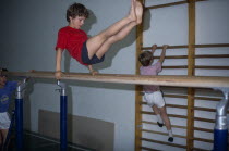 Boys using parallel bars and climbing frame in Holland.