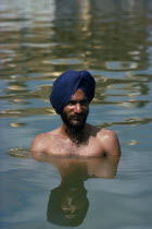 Hari Mandir or Golden Temple. Ritual bather in the Pool of Immortality to attain spiritual purification.worship pure purity Asia Asian Bharat Immature Inde Indian Intiya One individual Solo Lone Soli...