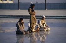 Faisal Mosque. Four men at prayer  reflected in surface of  shiny marble floor.worship 4 Asia Asian Male Man Guy Pakistani Religion Religious