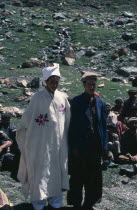 Shani Muslim village wedding ceremony with groom in white robes and male villagers sitting on groundAsia Asian Islam Marriage Moslem Pakistani Religion Religion Religious Muslims Islam Islamic