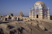 Tomb of Bibi Jawindi with domed roof and two similar crumbling buildings with dusty graveyard in the foreground2 Asia Pakistani Religion