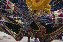 Crop Over sugar cane harvest festival.  Grand Kadooment carnival parade performer in elaborate black  red  yellow and green masked costume.Barbadian West Indies