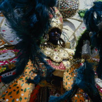 Carnival dancer wearing brightly coloured extravagant costume.