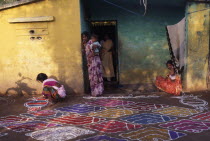 Pongal festival marking the end of harvest and lasting four days.  Women painting decorative pattern on ground outside home.4 Asia Asian Bharat Female Woman Girl Lady Inde Indian Intiya Religion