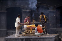 Cremation at Pashupatinath Temple.  Men gathered to light funeral pyre.Asia Asian Male Man Guy Nepalese Religion Religious
