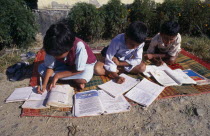 School children doing school work at a country school  outside on a blanketAsia Asian Kids Learning Lessons Llankai Sri Lankan Teaching