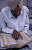 Man reading Sikh holy book at the Golden Temple. worship Asia Asian Bharat Inde Indian Intiya Male Men Guy One individual Solo Lone Solitary Religion Religion Religious Sihism Sikhs