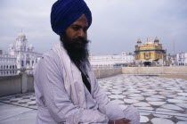 Golden Temple.  Sikh pilgrim with temple seen behind.Asia Asian Bharat Inde Indian Intiya One individual Solo Lone Solitary Religion Religion Religious Judaism Jew Jews Religion Religious Sihism Sikh...