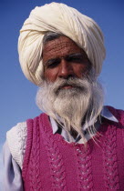 Elderly bearded Sikh man  head and shoulders portrait wearing white turban and pink knitted tank top.Asia Asian Bharat Inde Indian Intiya Male Men Guy Old Senior Aged One individual Solo Lone Solitar...