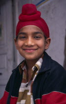 Portrait of smiling Sikh boy with his hair tied up in a topknot.Asia Asian Bharat Happy Immature Inde Indian Intiya Kids One individual Solo Lone Solitary Religion Religious Sihism Sikhs