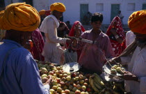 Vendor weighing apples for customer in fruit market.transaction Asia Asian Bharat Inde Indian Intiya Rajasthani