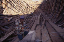 Shipbuilding.  Men work on interior of boat. Asia Asian Bharat Inde Indian Intiya Male Man Guy