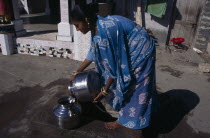 Young woman wearing blue  printed sari fetching water from well in street.Asia Asian Bharat Female Women Girl Lady Immature Inde Indian Intiya One individual Solo Lone Solitary