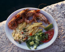 Plate of shrimps with rice  chips and saladGreek tourist meal