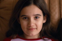 Portrait of smiling girl aged eleven with brown eyes and hair.