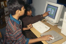 Two young boys learning English through computer games.2 Asia Asian Bangladeshi Dacca Immature Kids Lessons Teaching