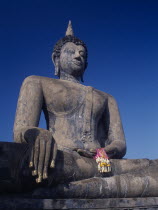 Wat Mahathat. Seated Buddha statue holding pink ribbon flower garlandsAsian History Prathet Thai Raja Anachakra Thai Religion Religious Siam Southeast Asia