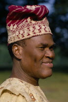 Yoruba chief.  Portrait wearing hat and robe.