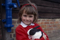 Young girl holding a black and white rabbit at Finkley Down Farm