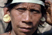 Portrait of a Waorani Indian woman wearing balsa ear plugs.