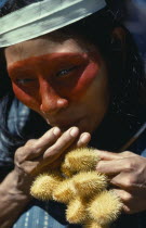 Auca Indian woman with achole plant from which the red colouring used as face paint is obtained.