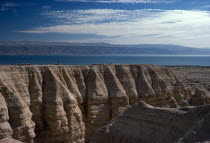 View over rocky eroded cliffs to the Dead Sea beyond