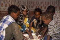 Children eating meal at home from communal dish using the right hand.  At a family meal men are usually served first and women and children eat seperately later.
