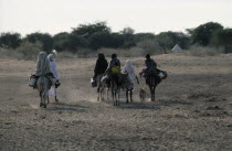 Baggara Arabs from the Beni Halba tribe on foot and donkey in semi desert area.