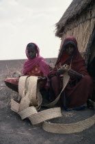 Women weaving palm leaves to make baskets.Africa African Female Woman Girl Lady North Africa Sudanese