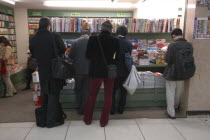 Tokyo Station  men at a book shop doing tateyomi  standing and reading.Asia Asian Japanese Nihon Nippon Store Male Man Guy
