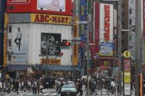 The main intersection outside Shinjuku Station  crowds crossing the road  advertising on buildings.Asia Asian Japanese Nihon Nippon