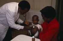 Doctor listening to chest of child in clinic in Kariobangi slum area.