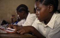Schoolchildren working at desks in classroom at Mwenge Primary School.