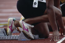 Cropped view of runner on starting blocks at the start of 100 m event.