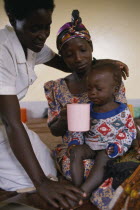 Nurse comforting mother with child with malaria in hospital in Orukinga refugee camp near the Rwandan border.