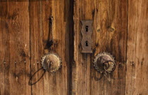 Detail of wooden door and traditional metal handle.