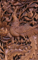 Detail of traditional door carving depicting bird  leaves and flowers.