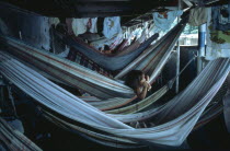 Child lying in hammock accommodation on Amazon river boat between Belem and Manaus