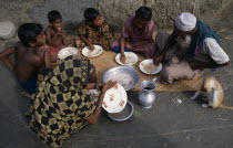 Family having breakfast of rice  seated on mat laid on ground and eating with their right hands.meal Asia Asian Bangladeshi Kids