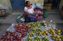 Woman sitting behind street stall display selling onions  garlic and fruit.American Female Women Girl Lady Hispanic Latin America Latino Mexican One individual Solo Lone Solitary 1 Female Woman Girl...