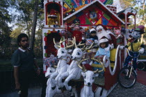 Children visiting Father Christmas in his sleigh in Mexico City ParkAmerican Dad Hispanic Kids Latin America Latino Mexican Xmas