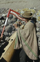Quechua Indian man playing traditional harp.