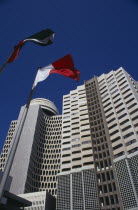 Deira Tower.  Looking up at high rise building with flags flying in foreground.Dubayy United Arab Emirates Al-Imarat Al-Arabiyyah Al-Muttahidah Arabic Dubai Emiriti Middle East