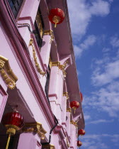 Pink and gold painted shopfront hung with red and gold Chinese lanterns for Chinese New Year.Asian Malaysian Southeast Asia