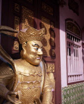 Gold painted statue outside wholesaler shopfront during Chinese New Year.Asian Malaysian Southeast Asia