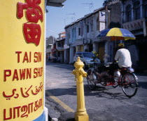 Lebuh Chulia.  Cycle rickshaw on street with yellow and red painted sign for pawn shop written in four different languages in immediate foreground.4 Asian Malaysian Southeast Asia Store