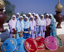 Group of young Muslim Thai women standing behind blue  red  pink and green painted parasols at the Royal Flora Expo.Asian Female Woman Girl Lady Immature Islam Moslem Prathet Thai Raja Anachakra Thai...